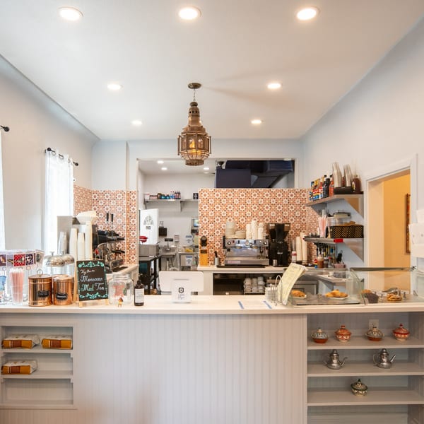 Cafe Miriam's bright, clean counter area with coffee machines, pastries, and Moroccan decor.