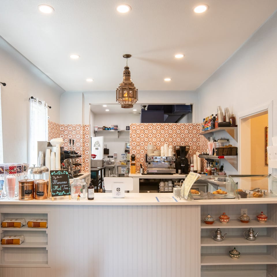 Cafe Miriam's bright, clean counter area with coffee machines, pastries, and Moroccan decor.