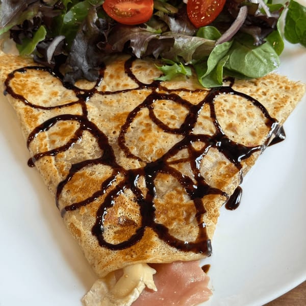 Savory crepe with ham, cheese, and balsamic glaze, served with a side salad at Cafe Miriam.
